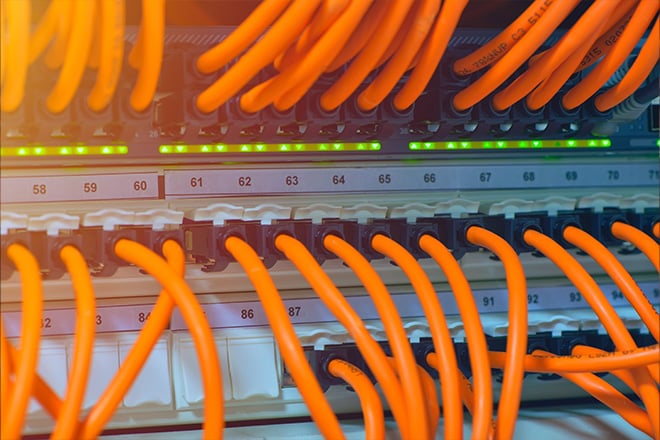 Orange network wires connected via ethernet for a massive tech project.